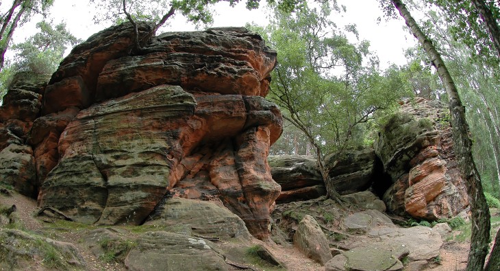 Ungewöhnliche Felsformation aus rotem Sandstein, bei der unterschiedliche Schichten gut zu erkennen sind.